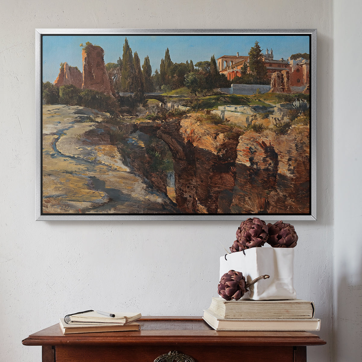 Silver floater framed canvas featuring Palatine in Rome, c. 1921 by Edward Theodore Compton above an entryway table in a minimalist foyer.
