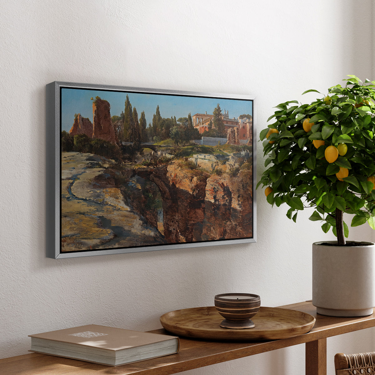 Palatine in Rome, c. 1921 by Edward Theodore Compton, presented in a silver floater framed canvas featuring historic Roman ruins and buildings set within warm landscape, displayed above a hallway console table.