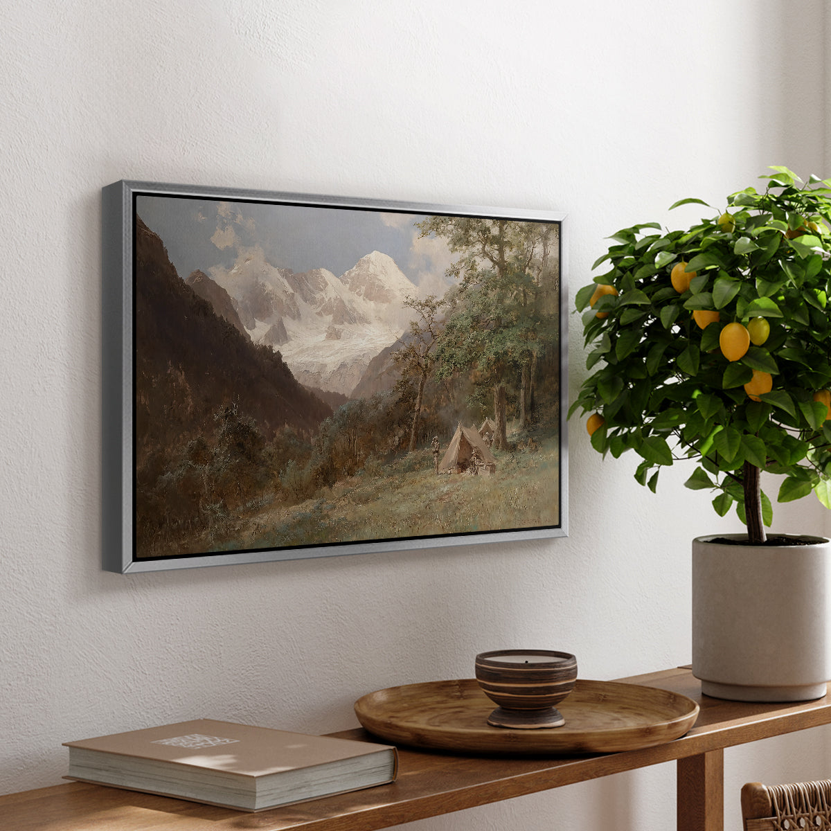 Landscape in the Caucasus, c. 1921 by Edward Theodore Compton, presented in a silver floater framed canvas featuring a mountainous landscape with rugged terrain and distant peaks, displayed above a hallway console table.