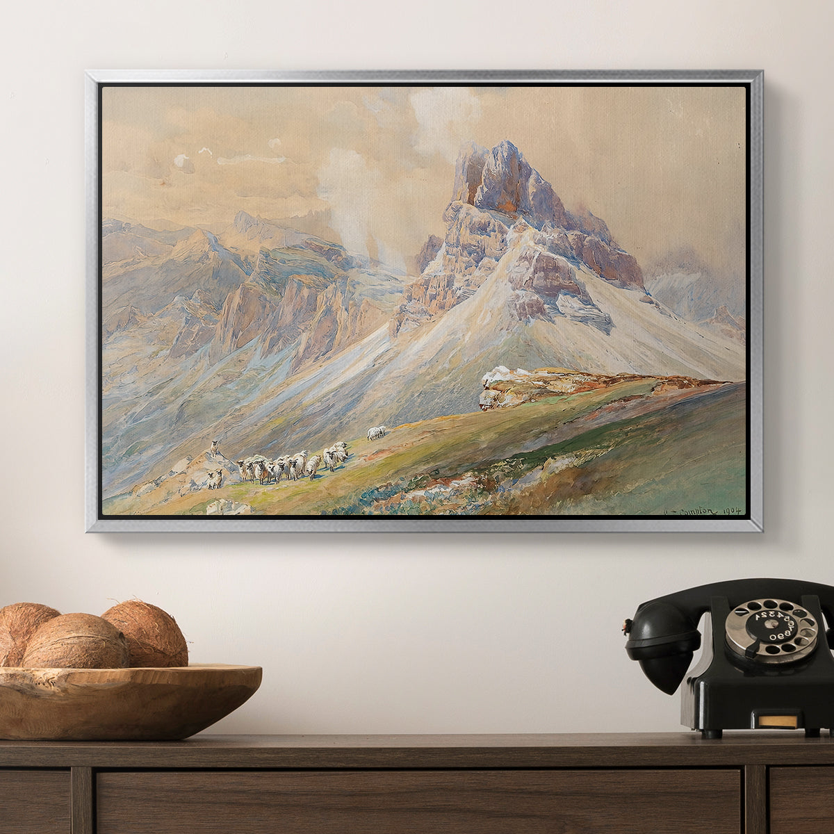From the Dolomites, 1904 by Edward Theodore Compton in a silver floater framed canvas displayed above a console table in a hallway, featuring a realistic mountain view with strong geological forms.