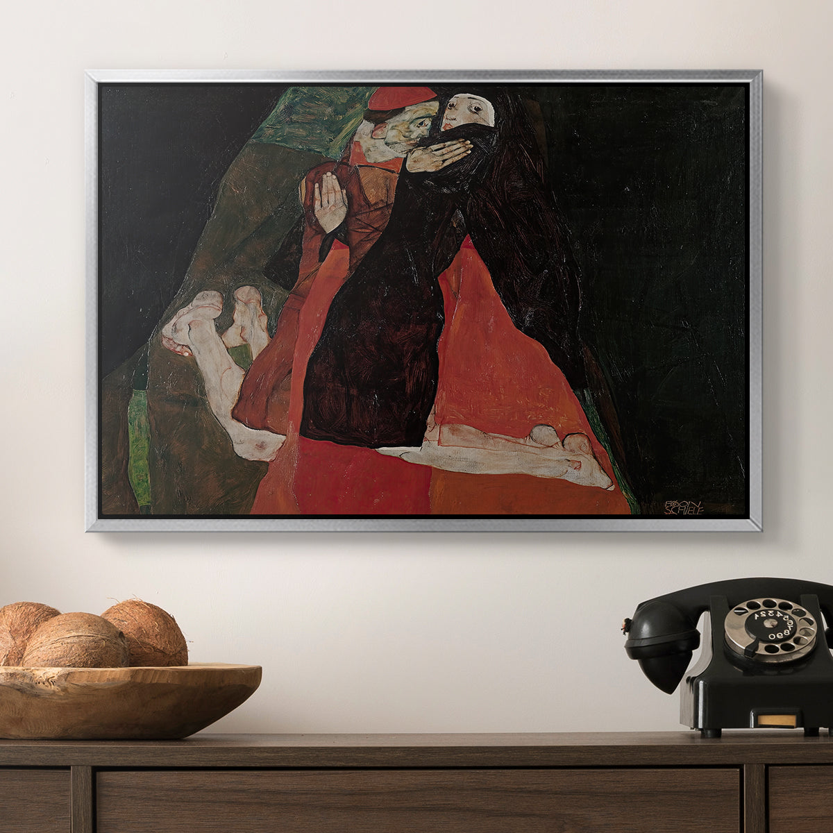 Cardinal and Nun (Caress), 1912 by Egon Schiele in a silver floater framed canvas displayed above a console table in a hallway, featuring an intimate scene with religious figures in modernist style.