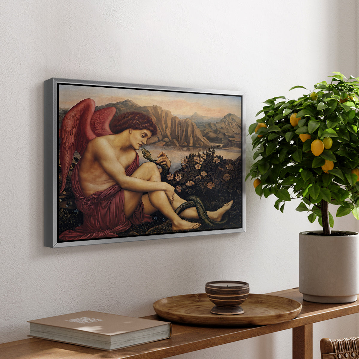 The Angel with the Serpent, c. 1870-1875 by Evelyn De Morgan, presented in a silver floater framed canvas featuring an angelic figure confronting serpent in symbolic battle of good and evil, displayed above a hallway console table.