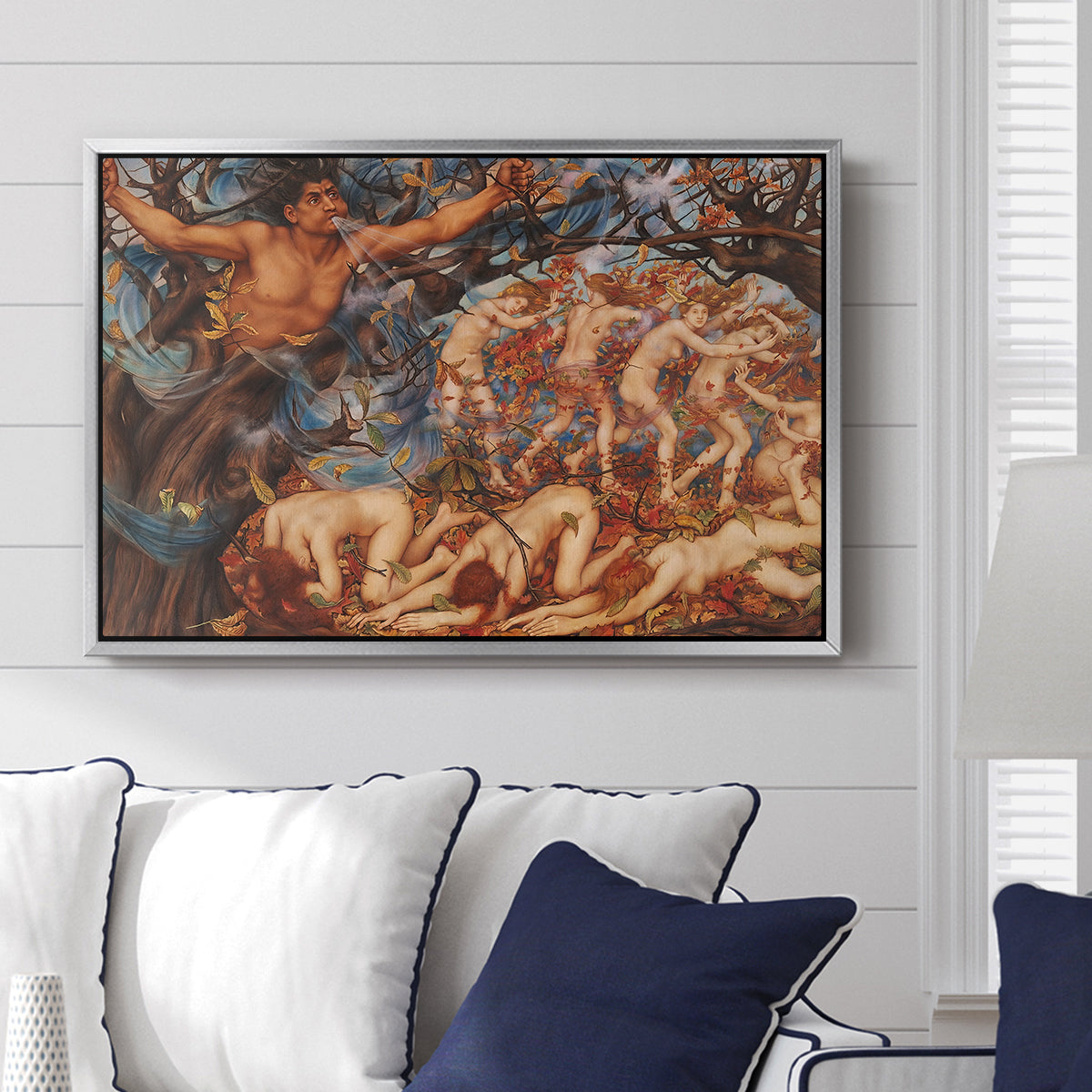 Boreas and the Fallen Leaves, c. 1910-1914 by Evelyn De Morgan displayed above a sofa in a living room in a silver floater frame, featuring a mythological scene of wind god Boreas moving through autumn leaves.