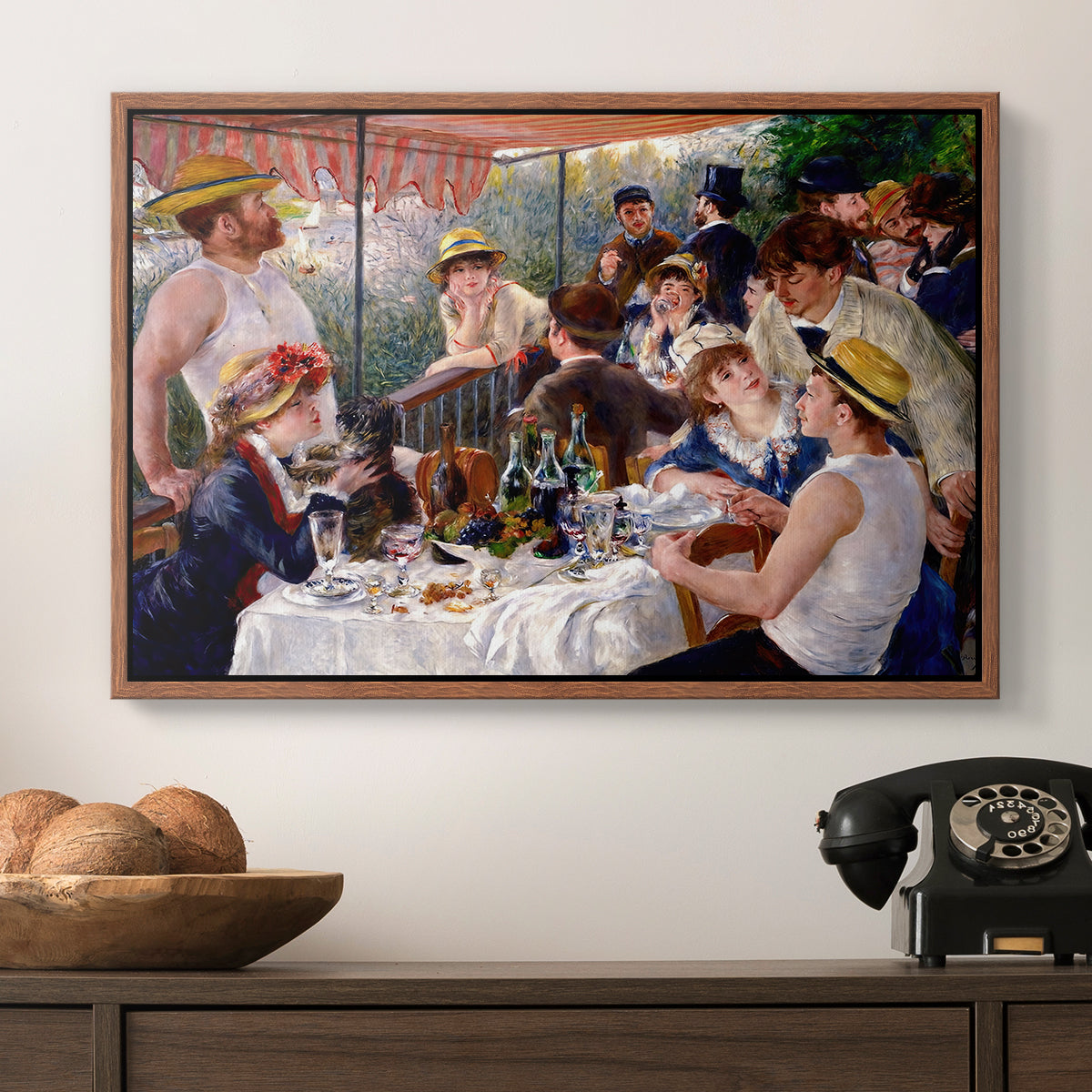 Luncheon of the Boating Party (Le Déjeuner des canotiers), 1880-1881 by Pierre-Auguste Renoir in a walnut floater framed canvas displayed above a console table in a hallway, featuring a social dining scene with figures seated around table on riverside terrace.