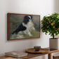 Tama, the Japanese Dog, c. 1876 by Pierre-Auguste Renoir, presented in a walnut floater framed canvas featuring a small black and white dog standing in shallow water with soft brushstrokes, displayed above a hallway console table.