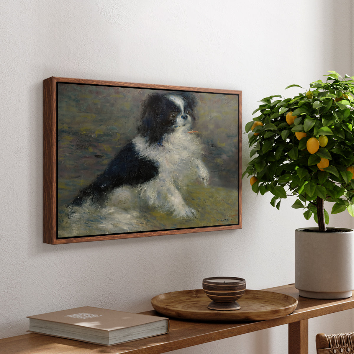 Tama, the Japanese Dog, c. 1876 by Pierre-Auguste Renoir, presented in a walnut floater framed canvas featuring a small black and white dog standing in shallow water with soft brushstrokes, displayed above a hallway console table.