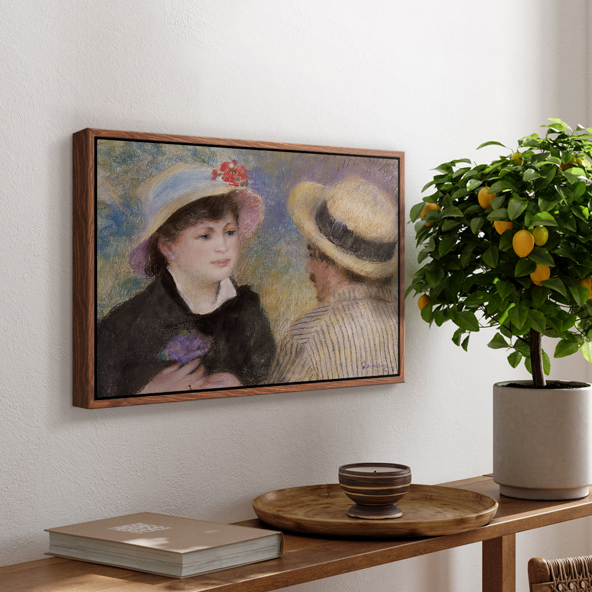 Boating Couple (Aline Charigot and Renoir), c. 1881 by Pierre-Auguste Renoir, presented in a walnut floater framed canvas featuring a close-up of a couple seated together outdoors with hats and soft sunlight, displayed above a hallway console table.
