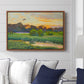 Flying Duck at Sunset, 1924 by Bruno Liljefors displayed above a sofa in a living room in a walnut floater frame, featuring a lone duck soaring over a glowing marshland.