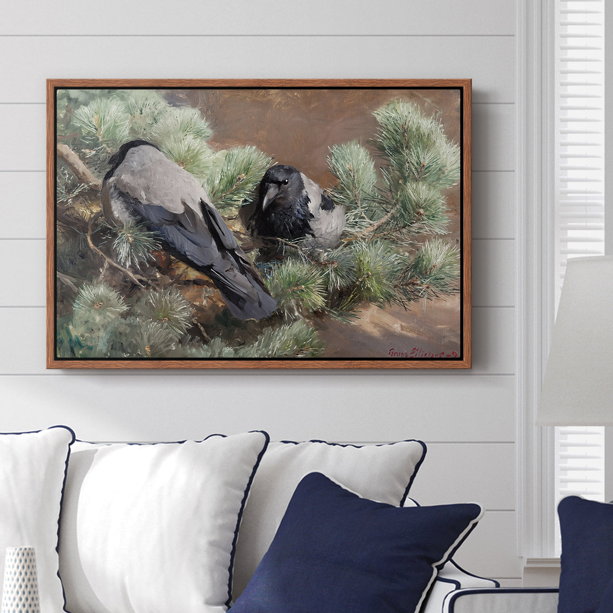 Hooded Crows (Kråkor), 1891 by Bruno Liljefors displayed above a sofa in a living room in a walnut floater frame, featuring birds standing alert in natural field environment.