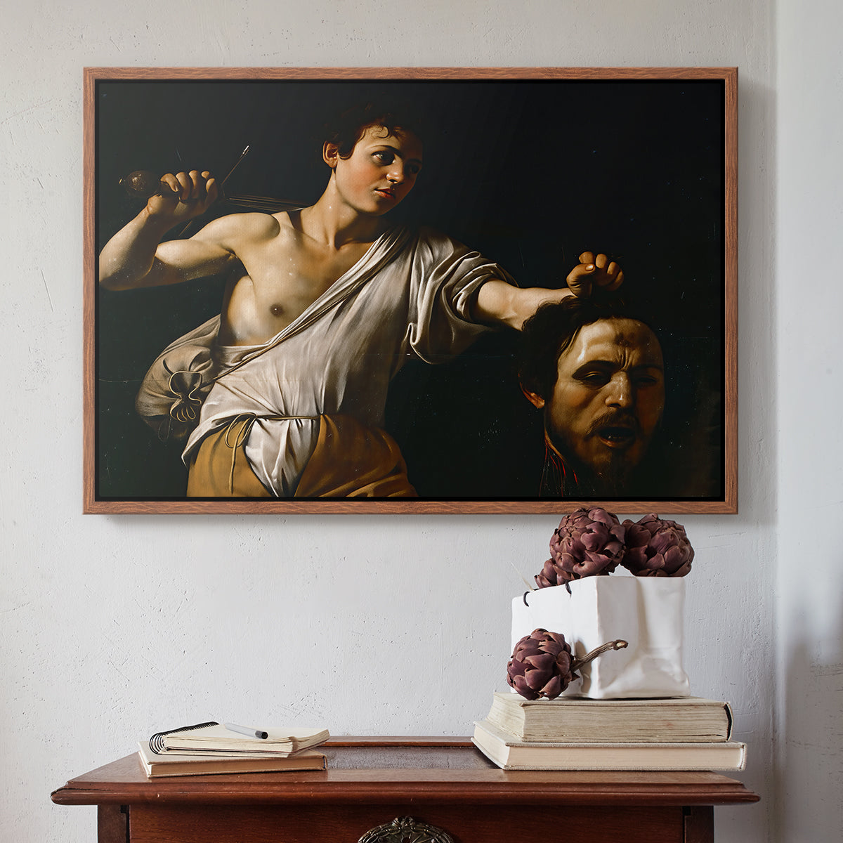 Walnut floater framed canvas featuring David with the Head of Goliath (Vienna Version), c. 1607 by Caravaggio above an entryway table in a minimalist foyer.