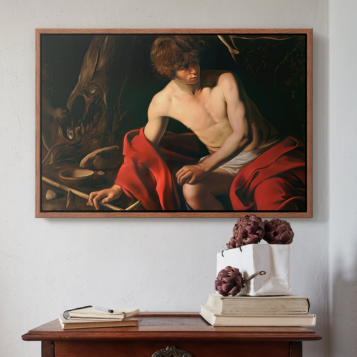 Walnut floater framed canvas featuring Saint John the Baptist in the Wilderness, c. 1603-1604 by Caravaggio above an entryway table in a minimalist foyer.