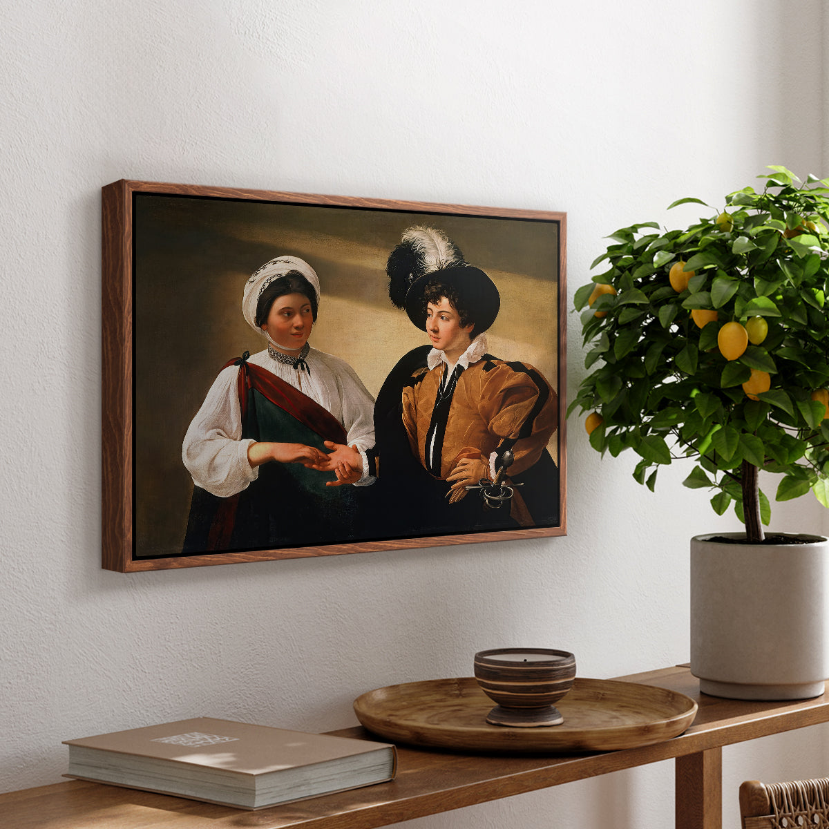The Fortune Teller (Louvre Version), c. 1595 by Caravaggio, presented in a walnut floater framed canvas featuring a woman reading a young man's palm while secretly stealing his ring, displayed above a hallway console table.