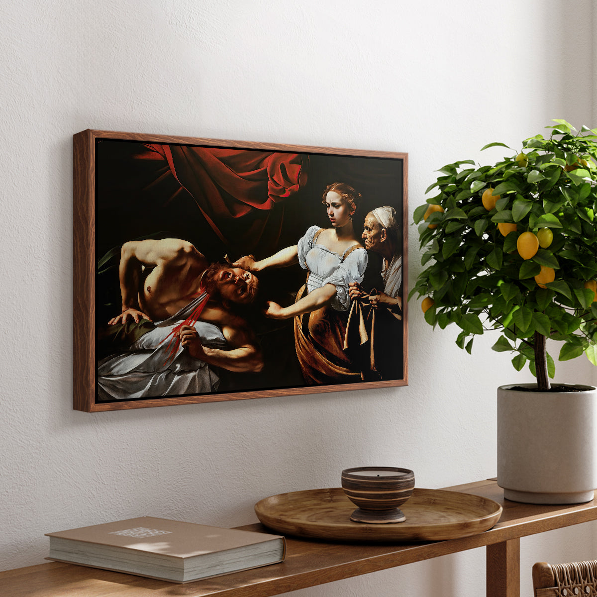 Judith Beheading Holofernes, c. 1599 by Caravaggio, presented in a walnut floater framed canvas featuring Judith cutting off Holofernes' head as maidservant assists beside her, displayed above a hallway console table.