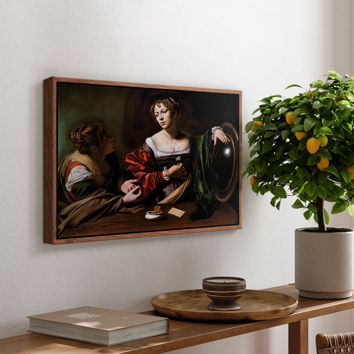 Martha and Mary Magdalene, c. 1598 by Caravaggio, presented in a walnut floater framed canvas featuring a two women seated together in conversation with symbolic objects on table, displayed above a hallway console table.