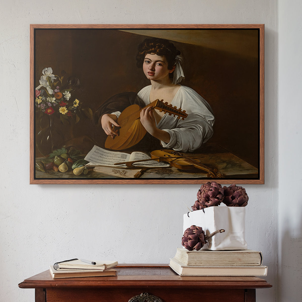 Walnut floater framed canvas featuring The Lute Player (Hermitage Version), c. 1596 by Caravaggio above an entryway table in a minimalist foyer.