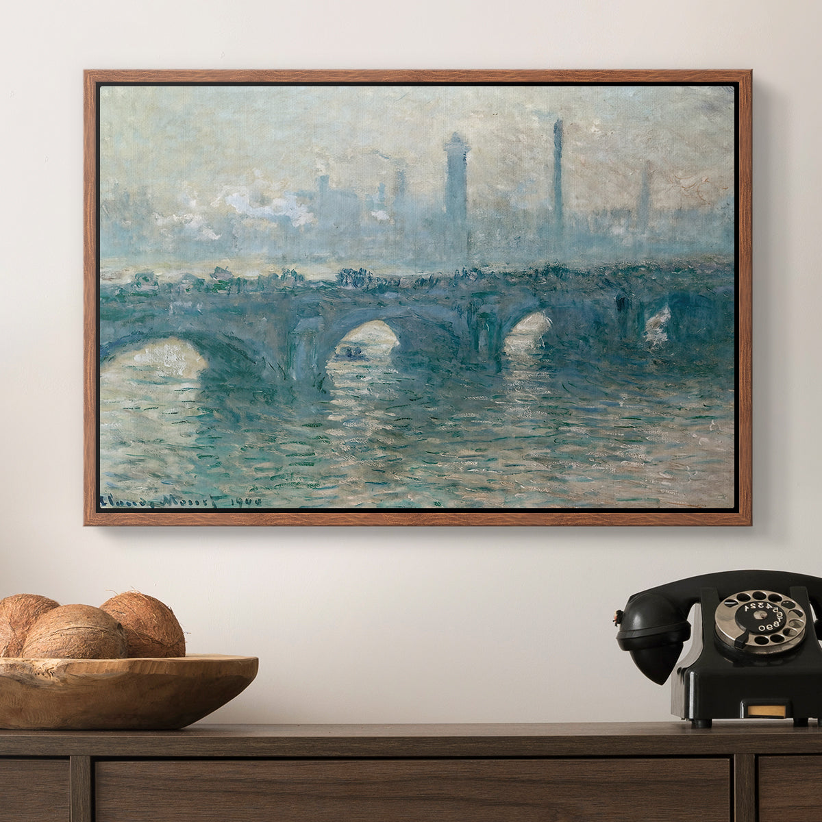 Waterloo Bridge, Gray Weather, 1900 by Claude Monet in a walnut floater framed canvas displayed above a console table in a hallway, featuring an atmospheric urban landscape with misty light and reflections.