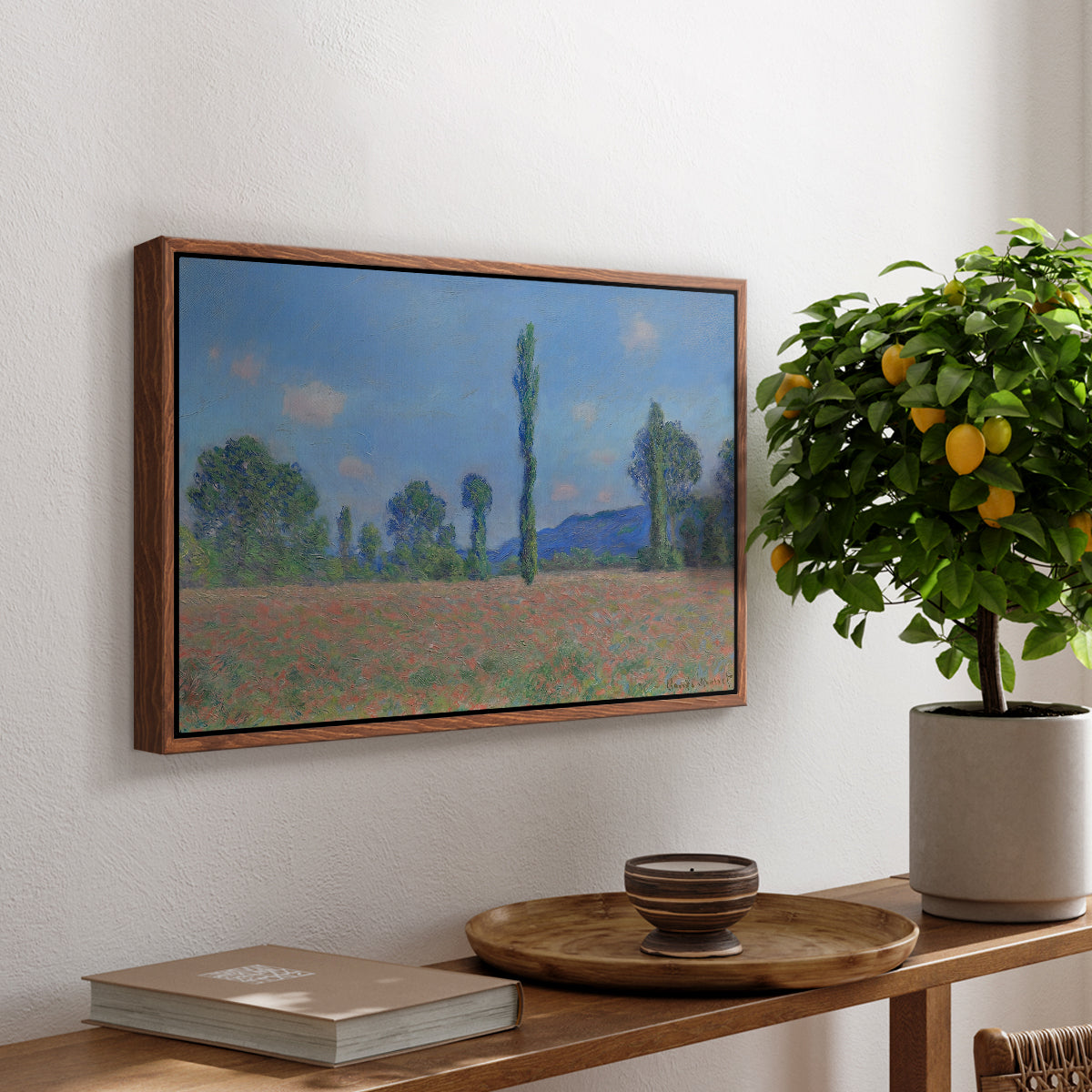 Poppy Field (Giverny), 1890-1891 by Claude Monet, presented in a walnut floater framed canvas featuring an expansive field of red poppies with tall trees under blue sky, displayed above a hallway console table.