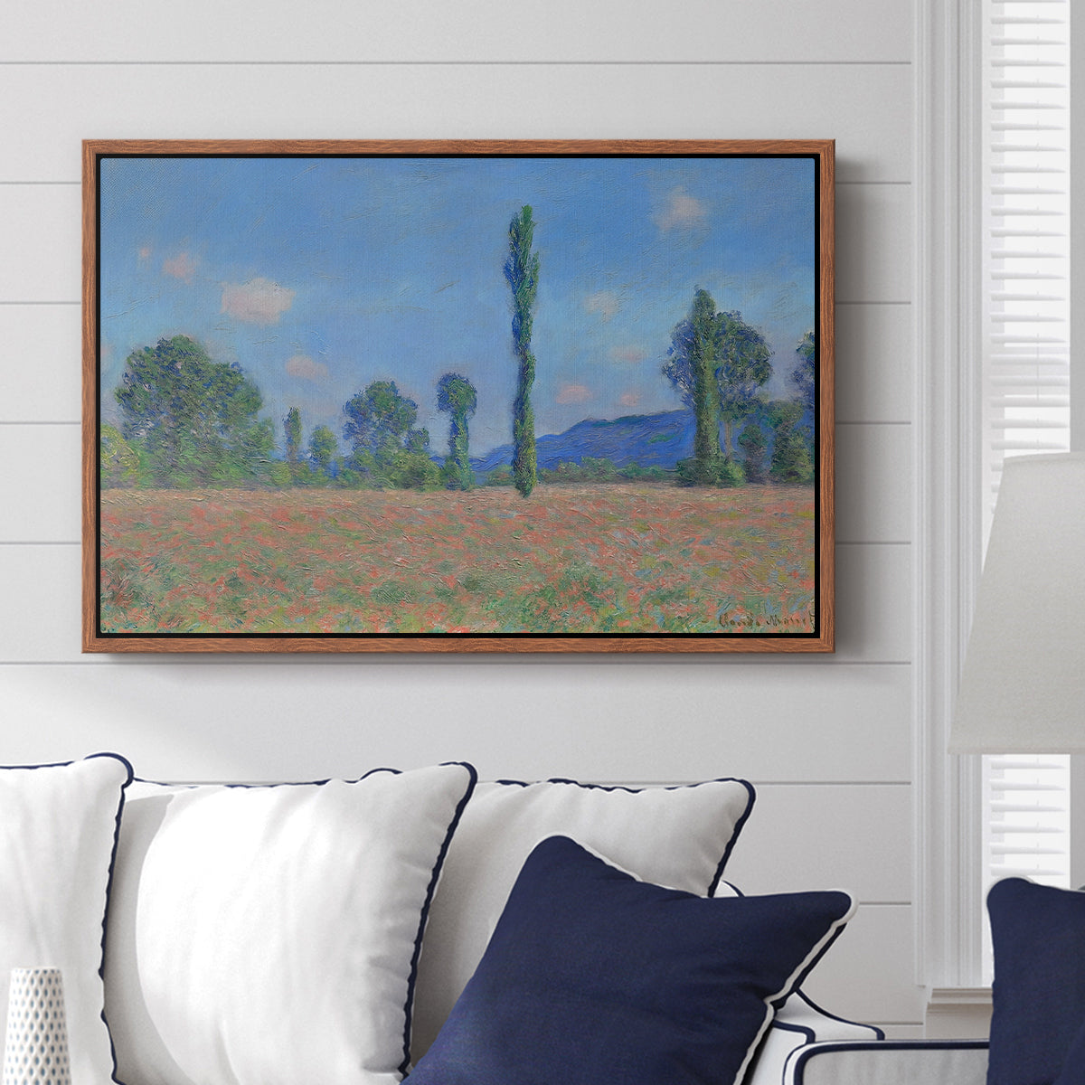 Poppy Field (Giverny), 1890-1891 by Claude Monet displayed above a sofa in a living room in a walnut floater frame, featuring an impressionist landscape of blooming poppies in countryside.