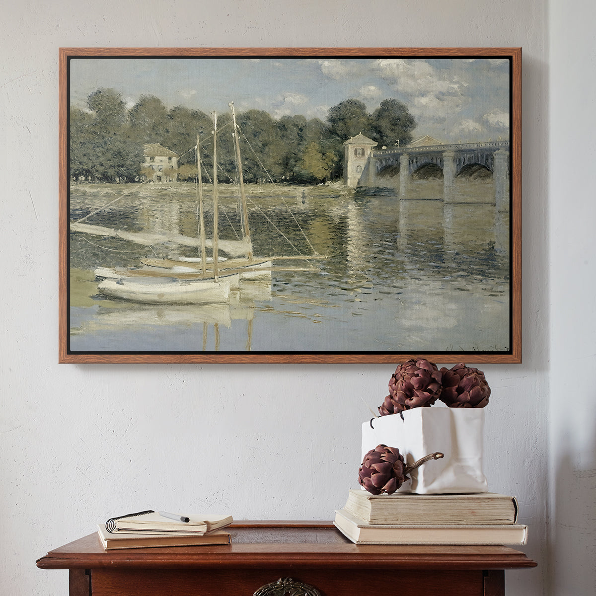 Walnut floater framed canvas featuring The Bridge at Argenteuil, 1874 by Claude Monet above an entryway table in a minimalist foyer.
