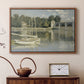 Walnut floater framed canvas featuring a bright landscape featuring bridge and sailboats on calm water, displayed above a cabinet in a soft-toned living room.