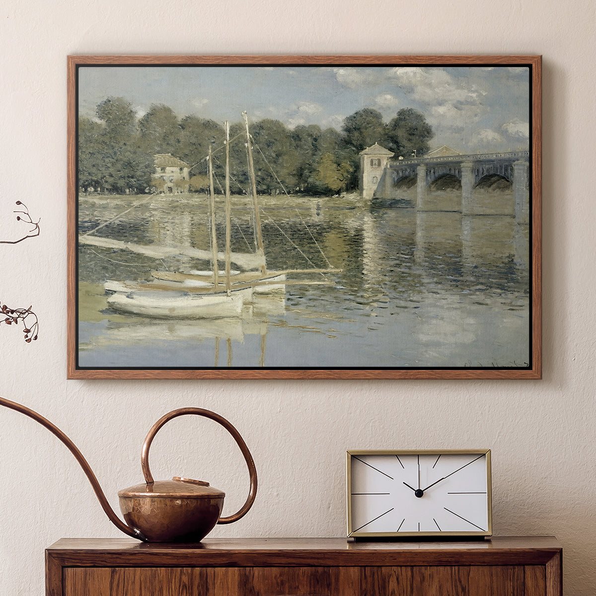 Walnut floater framed canvas featuring a bright landscape featuring bridge and sailboats on calm water, displayed above a cabinet in a soft-toned living room.