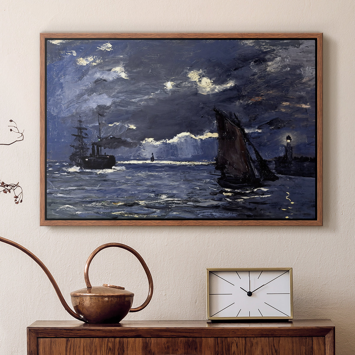 Walnut floater framed canvas featuring a dramatic ocean scene with light reflecting across water at night, displayed above a cabinet in a soft-toned living room.