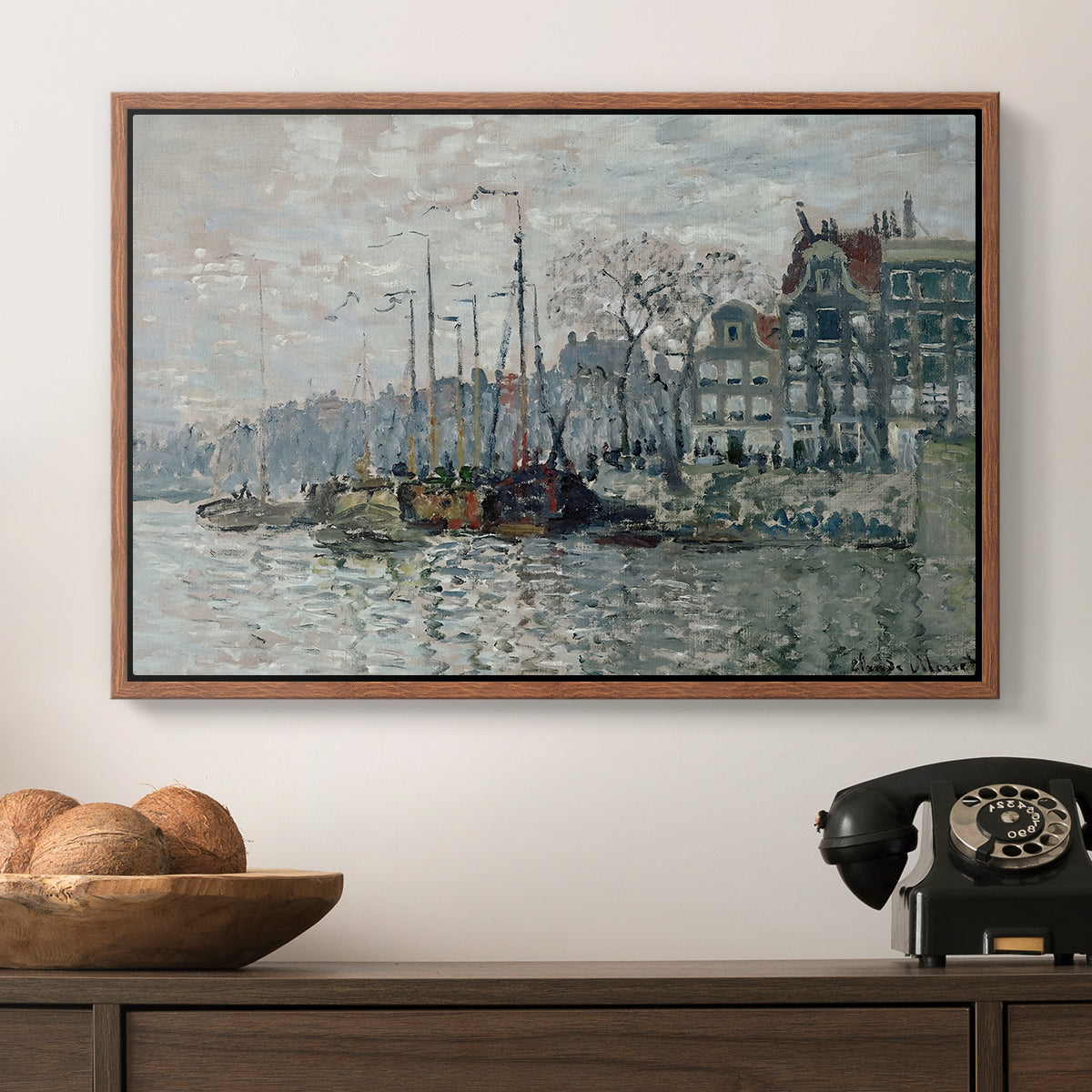 View of the Prins Hendrikkade and Kromme Waal in Amsterdam, 1874 by Claude Monet in a walnut floater framed canvas displayed above a console table in a hallway, featuring a harbor view with masts, houses, and reflections in water.