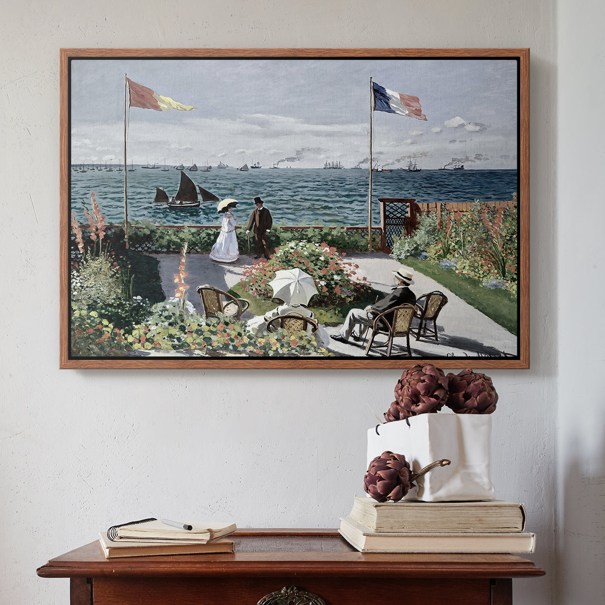 Walnut floater framed canvas featuring Garden at Sainte-Adresse, 1867 by Claude Monet above an entryway table in a minimalist foyer.