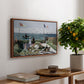 Garden at Sainte-Adresse, 1867 by Claude Monet, presented in a walnut floater framed canvas featuring a seaside garden with flowers, flags, and figures overlooking the water, displayed above a hallway console table.