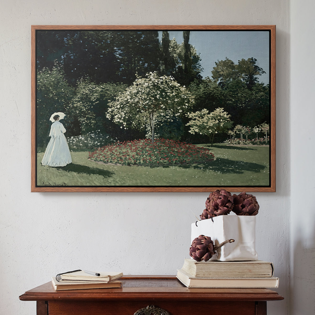 Walnut floater framed canvas featuring Woman in the Garden, Sainte-Adresse, 1867 by Claude Monet above an entryway table in a minimalist foyer.