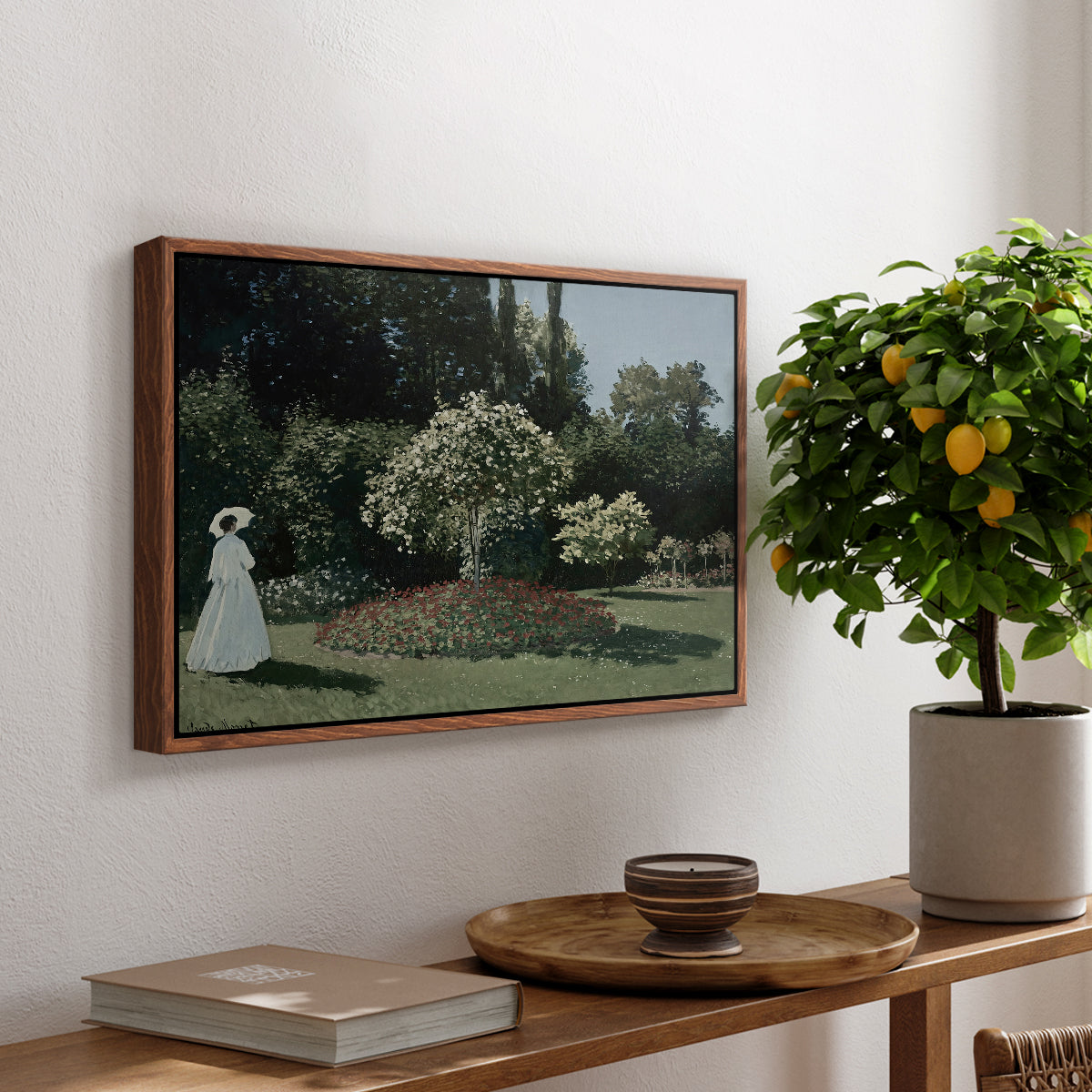 Woman in the Garden, Sainte-Adresse, 1867 by Claude Monet, presented in a walnut floater framed canvas featuring a woman standing in garden surrounded by flowers and greenery, displayed above a hallway console table.