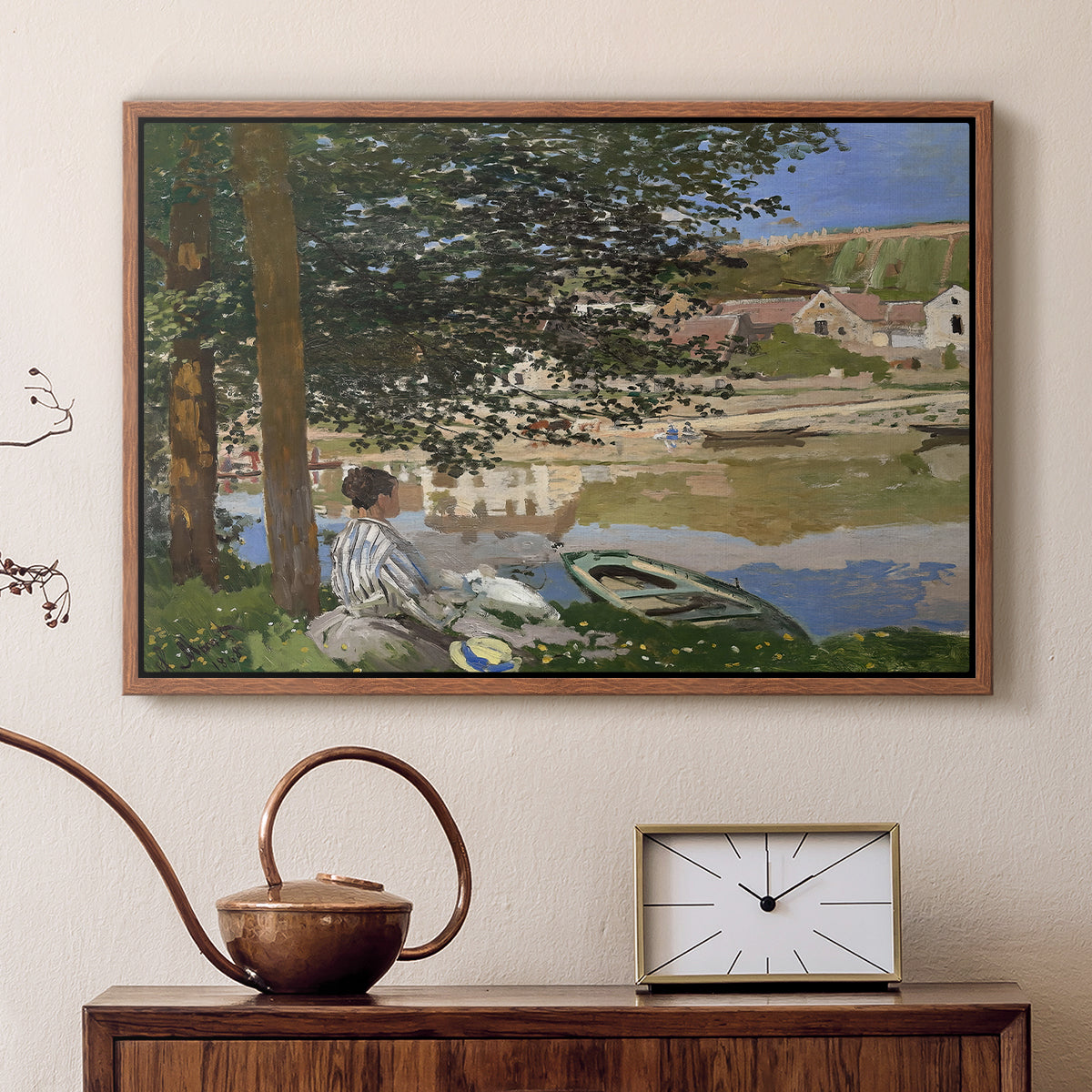 Walnut floater framed canvas featuring an impressionist landscape with people relaxing along the Seine, displayed above a cabinet in a soft-toned living room.