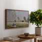 Summer (L'ete), 1874 by Claude Monet, presented in a walnut floater framed canvas featuring a woman seated in grassy field beneath tree in bright summer landscape, displayed above a hallway console table.