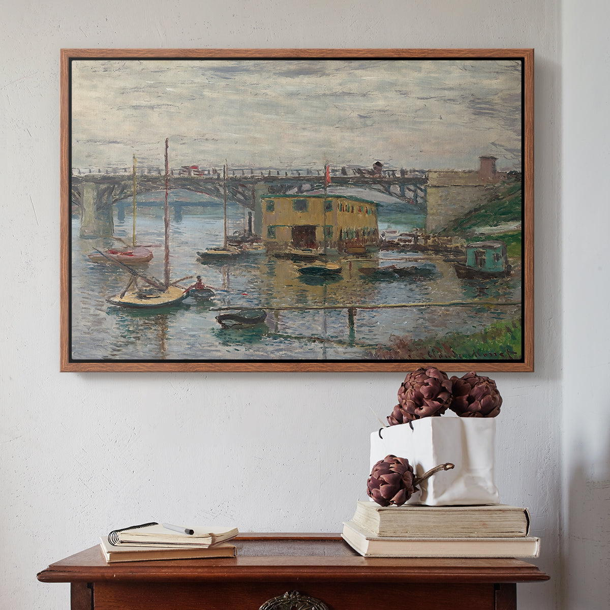 Walnut floater framed canvas featuring Bridge at Argenteuil on a Gray Day, c. 1876 by Claude Monet above an entryway table in a minimalist foyer.