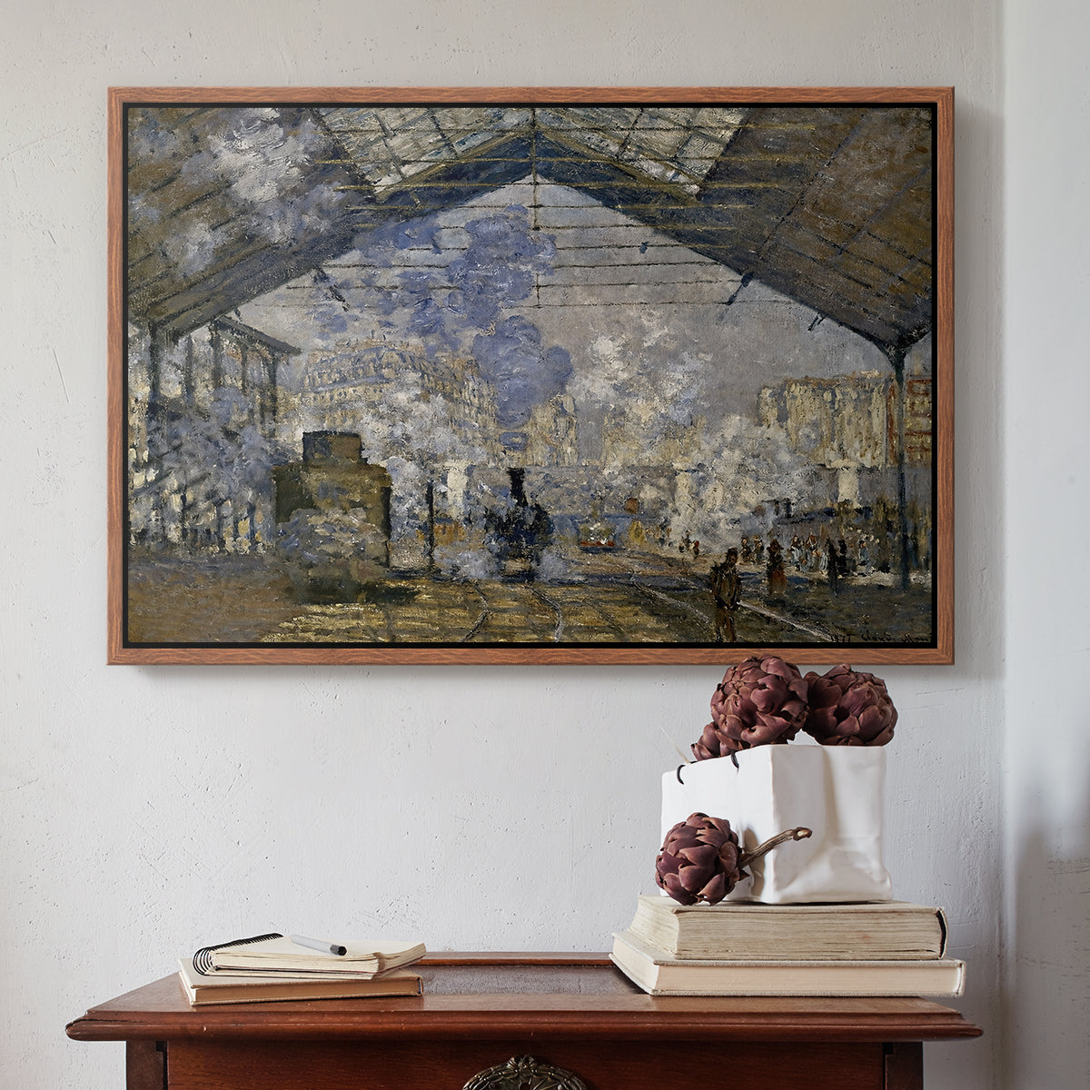 Walnut floater framed canvas featuring The Gare Saint-Lazare, 1877 by Claude Monet above an entryway table in a minimalist foyer.