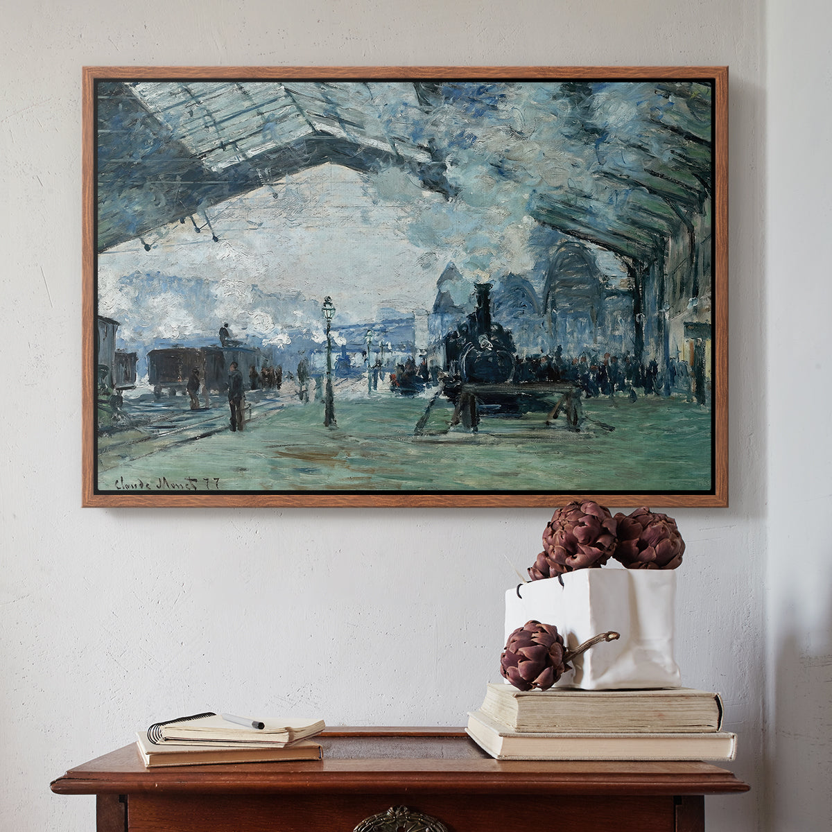 Walnut floater framed canvas featuring The Saint-Lazare Station, 1877 by Claude Monet above an entryway table in a minimalist foyer.