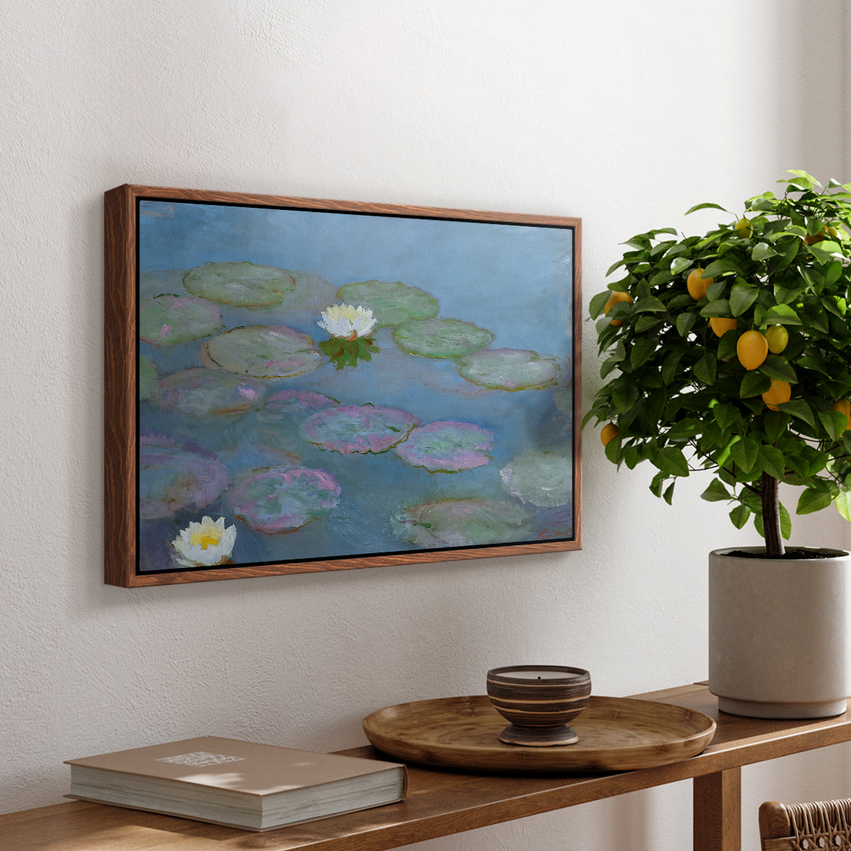 Water Lilies (Nymphéas), 1897-1899 by Claude Monet, presented in a walnut floater framed canvas featuring floating water lilies on pond with reflections of sky and foliage, displayed above a hallway console table.