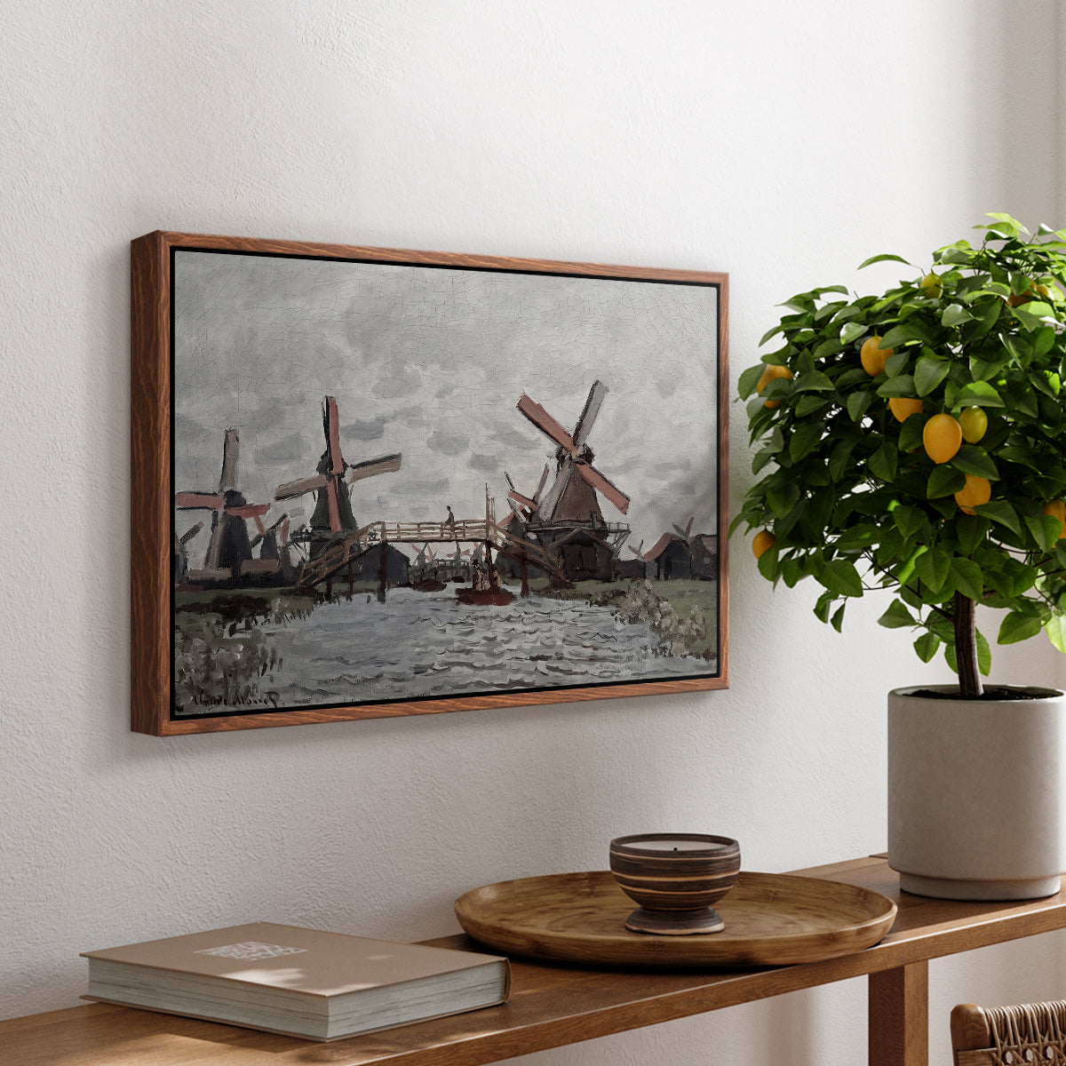 Windmills near Zaandam, 1871 by Claude Monet, presented in a walnut floater framed canvas featuring windmills standing beside water under open sky in rural landscape, displayed above a hallway console table.
