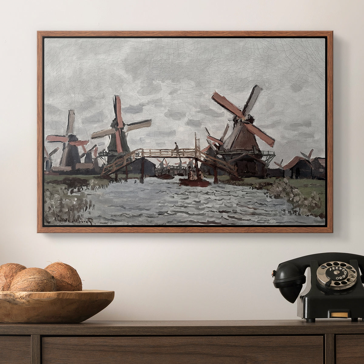 Windmills near Zaandam, 1871 by Claude Monet in a walnut floater framed canvas displayed above a console table in a hallway, featuring a landscape featuring windmills and low horizon sky.