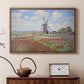 Walnut floater framed canvas featuring an impressionist field of blooming tulips under bright sky, displayed above a cabinet in a soft-toned living room.