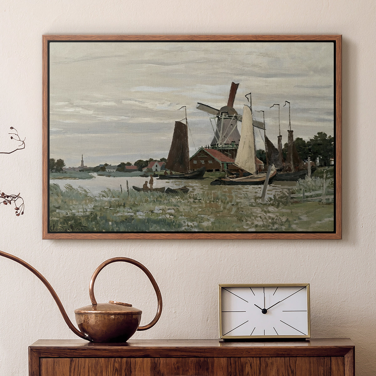 Walnut floater framed canvas featuring a rustic scene with windmill and reflections in water, displayed above a cabinet in a soft-toned living room.