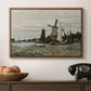 Windmill at Zaandam, 1871 by Claude Monet in a walnut floater framed canvas displayed above a console table in a hallway, featuring a countryside structure standing against open sky.
