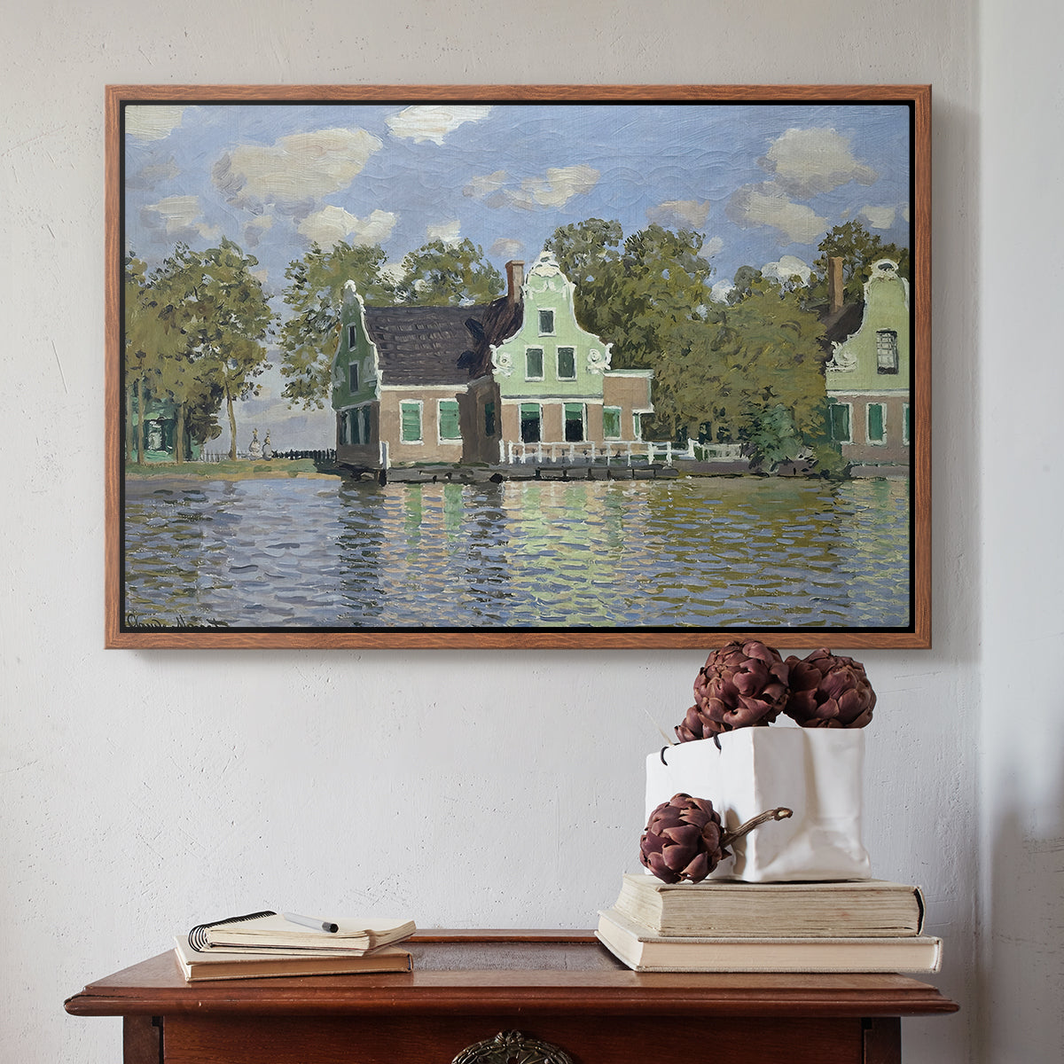 Walnut floater framed canvas featuring Houses on the Zaan River at Zaandam, 1871 by Claude Monet above an entryway table in a minimalist foyer.