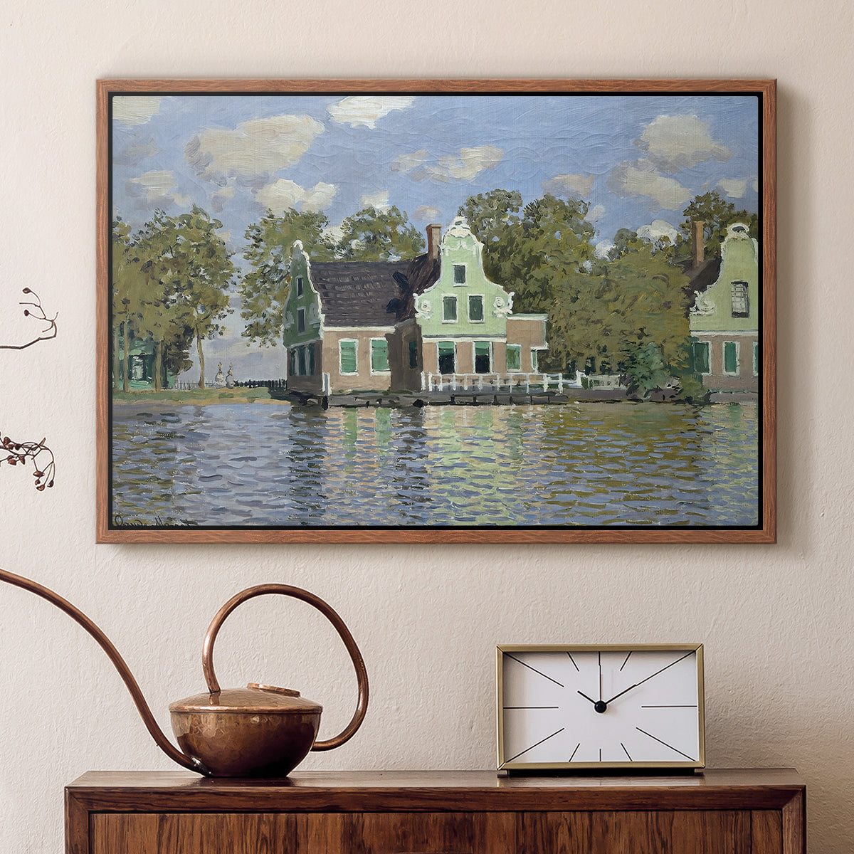 Walnut floater framed canvas featuring a peaceful canal scene with houses mirrored in water, displayed above a cabinet in a soft-toned living room.