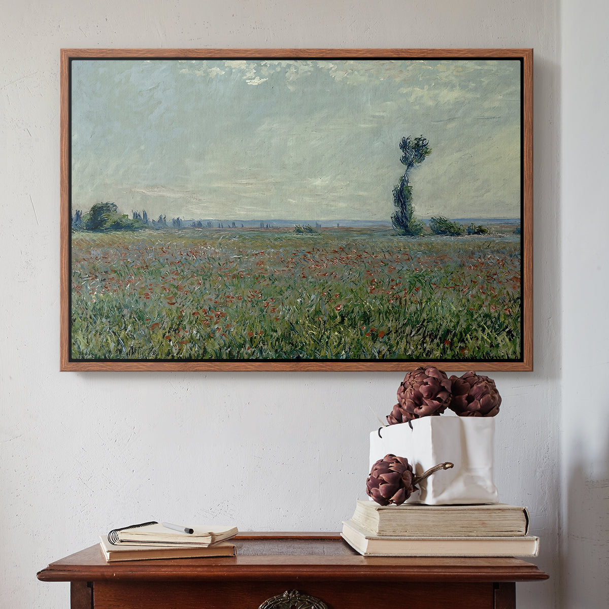 Walnut floater framed canvas featuring Poppy Field, 1881 by Claude Monet above an entryway table in a minimalist foyer.