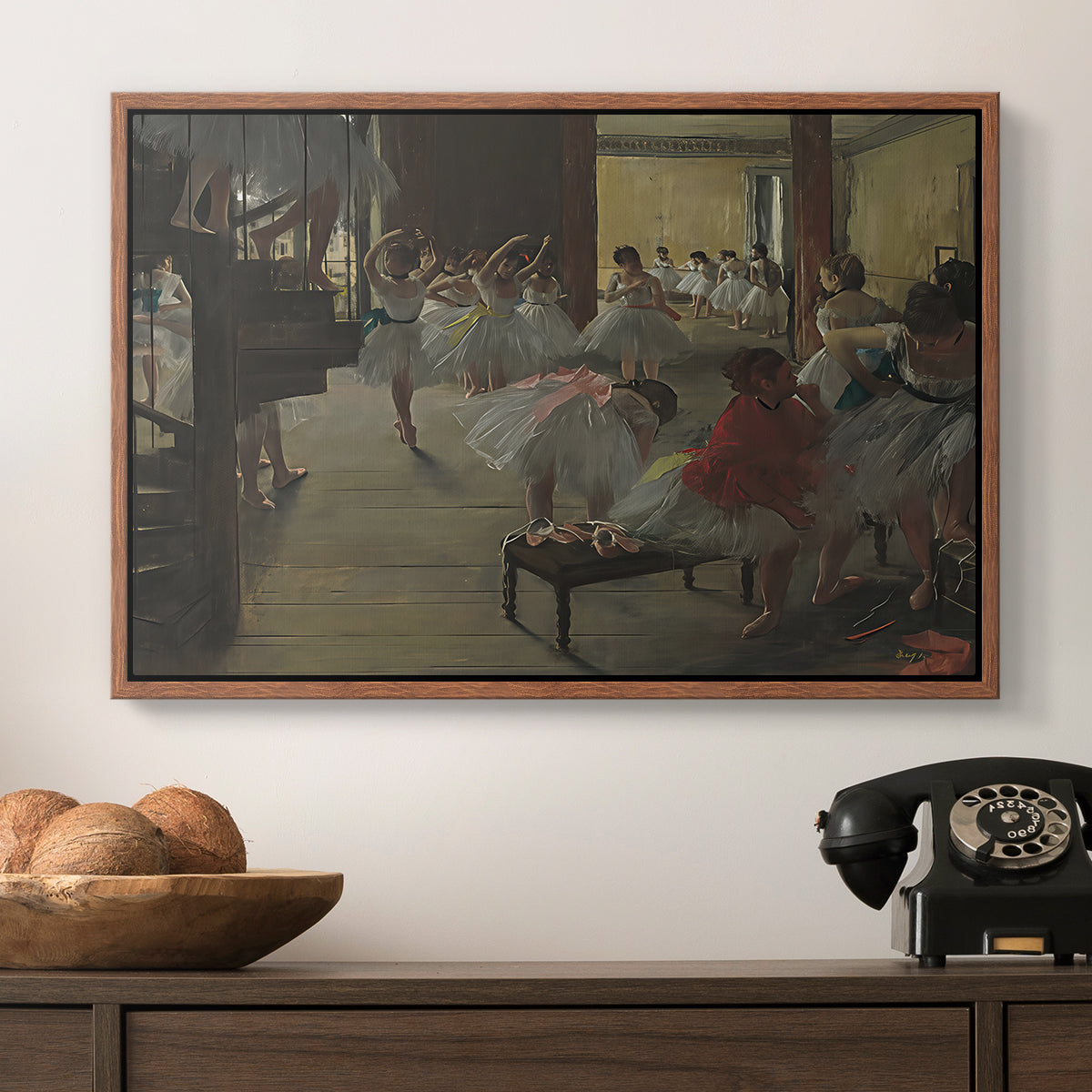 The Dance Class, c. 1873 by Edgar Degas in a walnut floater framed canvas displayed above a console table in a hallway, featuring a group of dancers preparing during class with natural light.