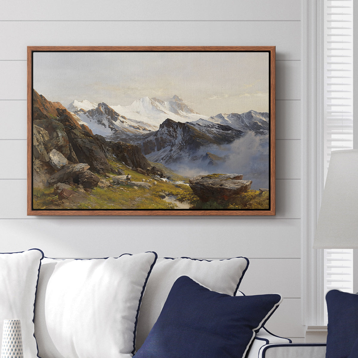 The Großglockner from the Prager Hut, 1890 by Edward Theodore Compton displayed above a sofa in a living room in a walnut floater frame, featuring a mountain summit seen from elevated viewpoint with surrounding landscape.