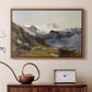 Walnut floater framed canvas featuring an alpine vista with towering peak and foreground terrain, displayed above a cabinet in a soft-toned living room.