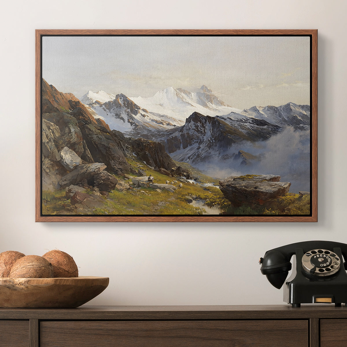 The Großglockner from the Prager Hut, 1890 by Edward Theodore Compton in a walnut floater framed canvas displayed above a console table in a hallway, featuring a scenic mountain view with dramatic elevation and depth.