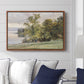 Landscape at Lake Starnberg, 1890 by Edward Theodore Compton displayed above a sofa in a living room in a walnut floater frame, featuring a peaceful lake scene with reflections and surrounding greenery.